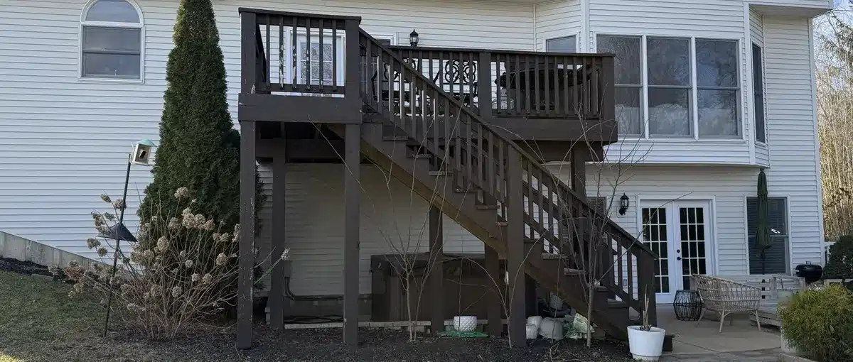 Aging wood deck with weathered boards and outdated railing before composite deck replacement in St. Louis