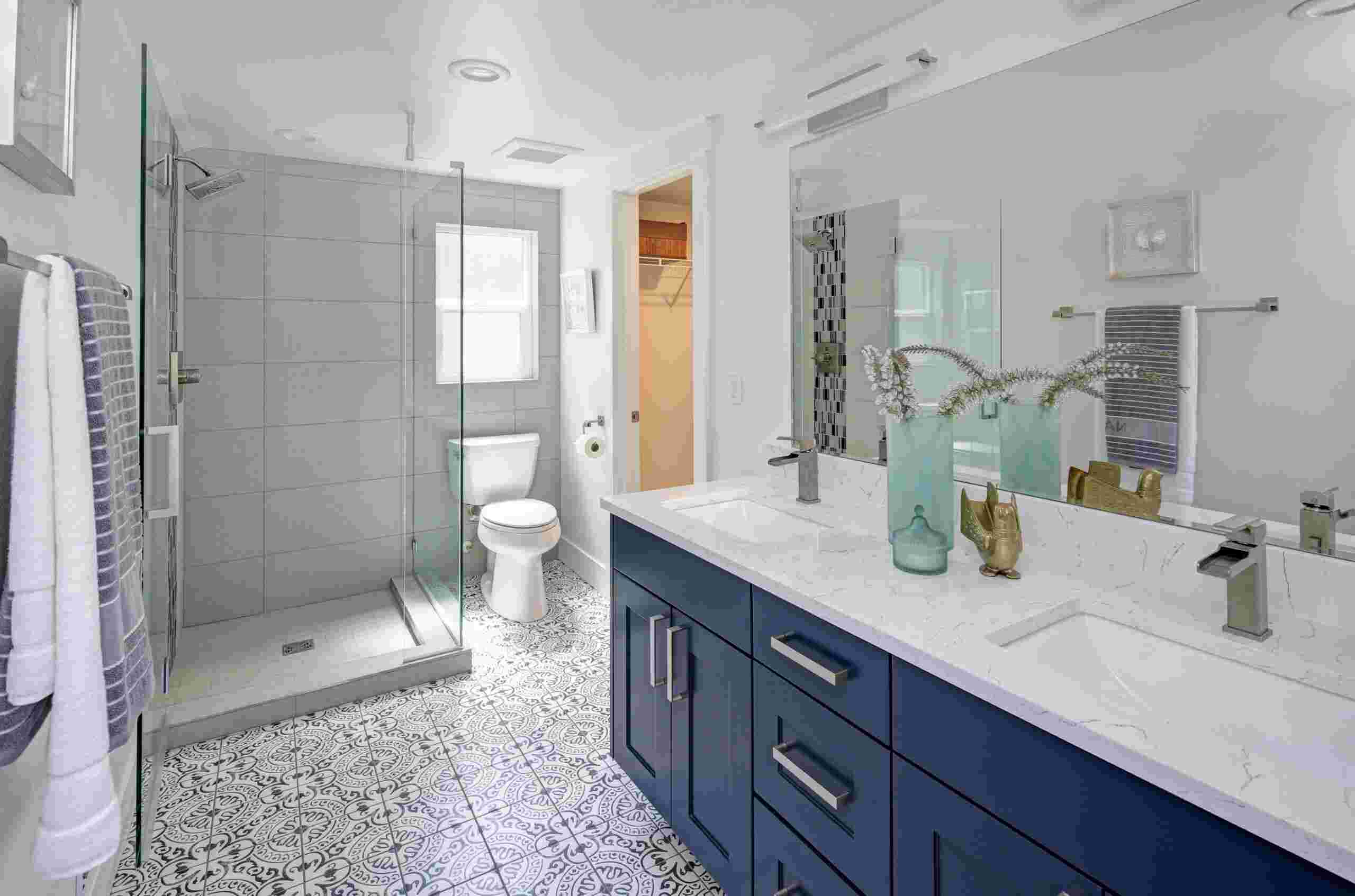 A bathroom with blue cabinets & white tile, showcasing bath remodeling services in St. Louis, MO